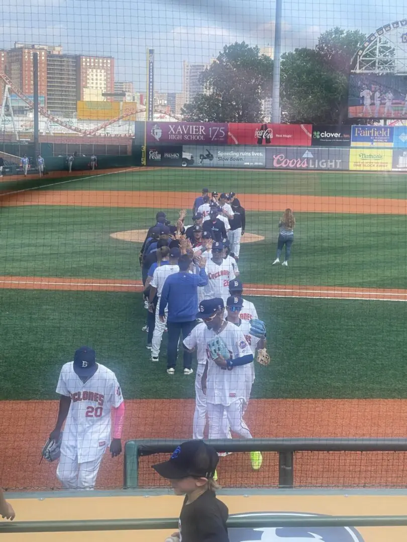 Baseball players line up to shake hands after a game.