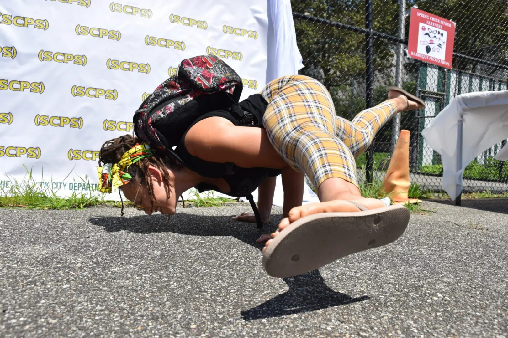 Woman balancing on a skateboard doing a yoga pose outdoors.