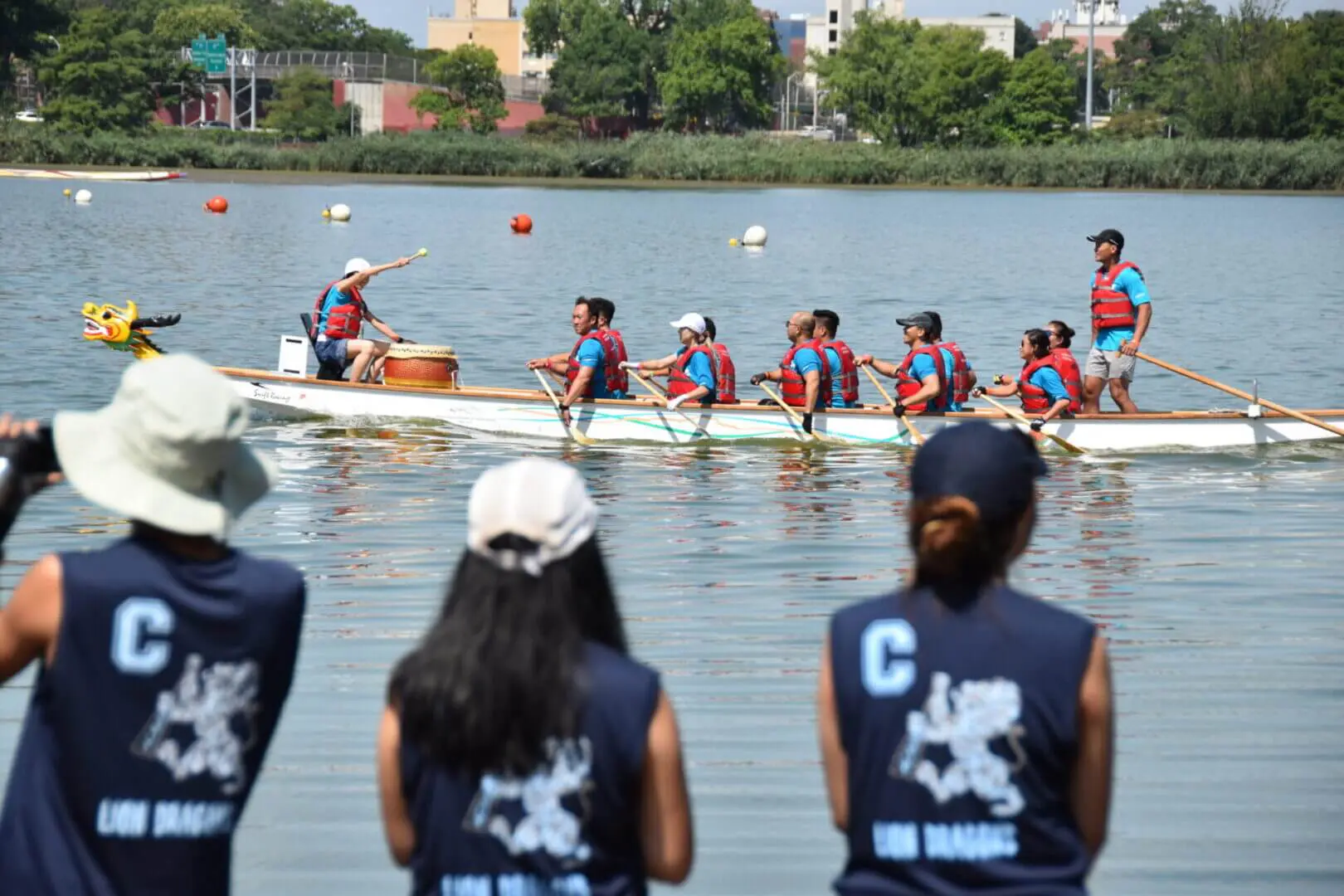 Two teams rowing on a lake under supervision.