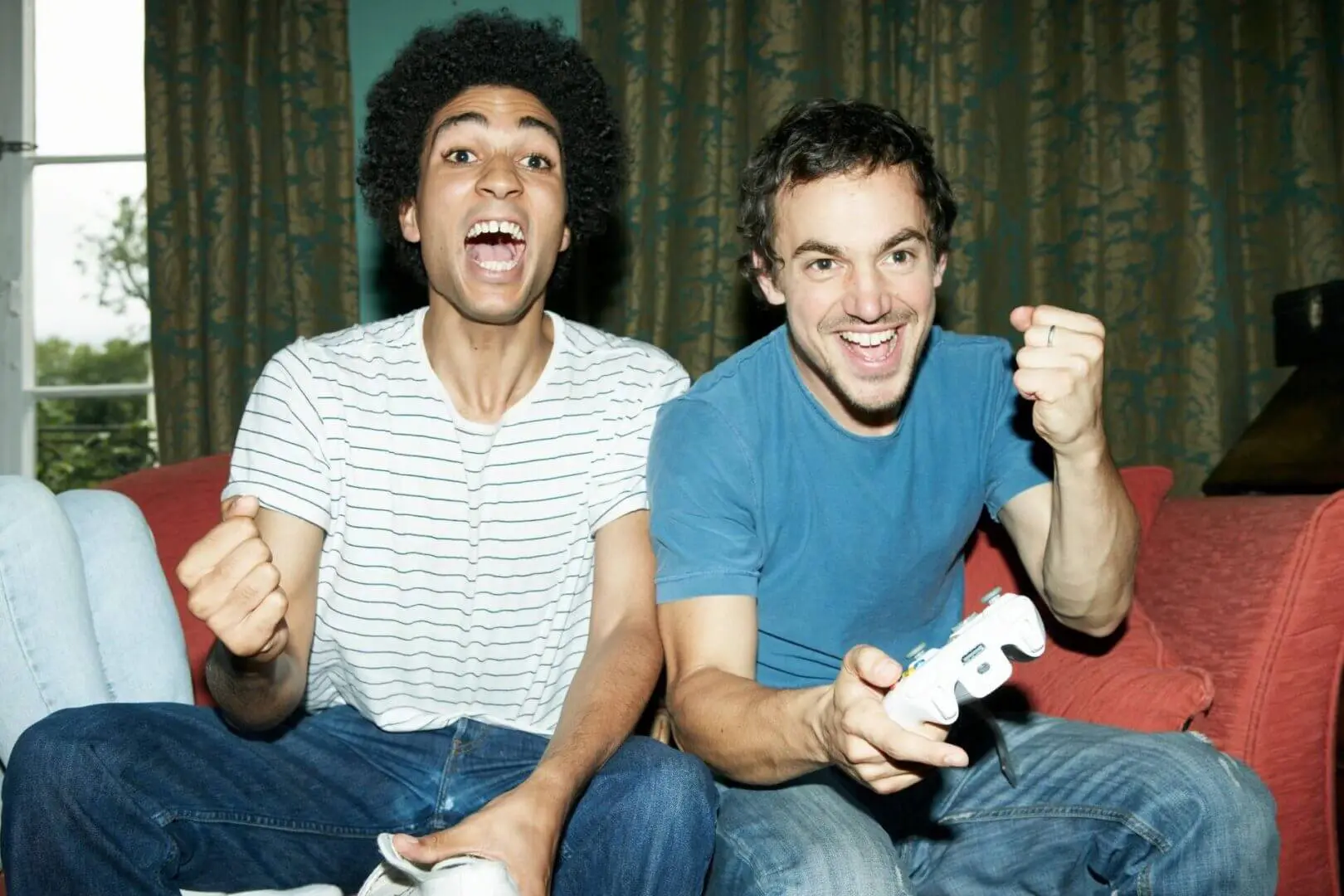 Two friends excitedly playing video games together.