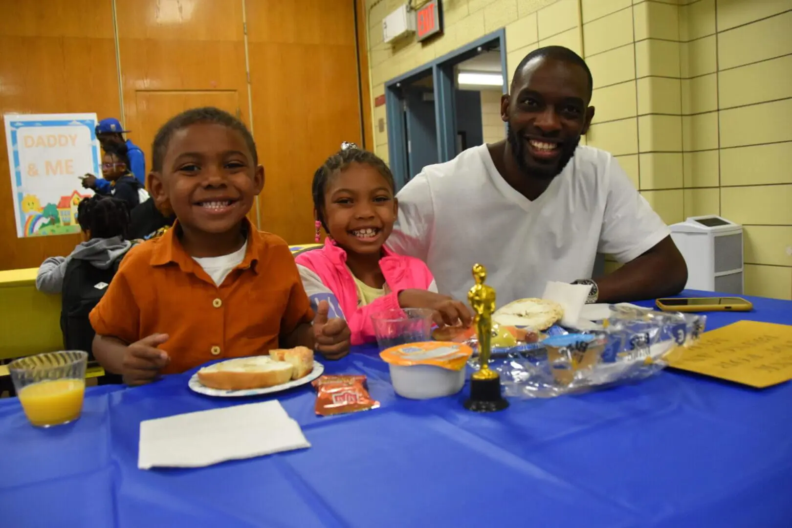 Smiling father and children enjoying a meal together at a celebration.