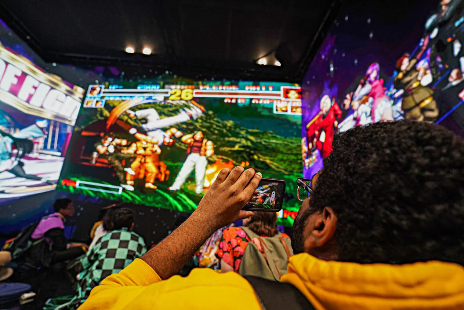 Person playing a colorful arcade fighting game indoors.