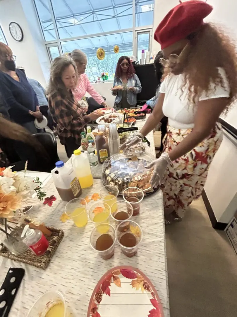 People enjoying a lively gathering with drinks and snacks on a festive table.