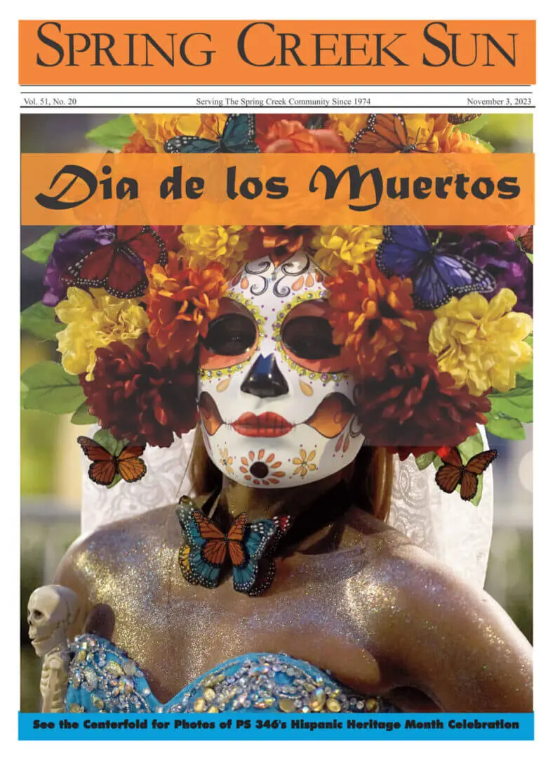 Woman with intricate Day of the Dead face paint and floral crown.