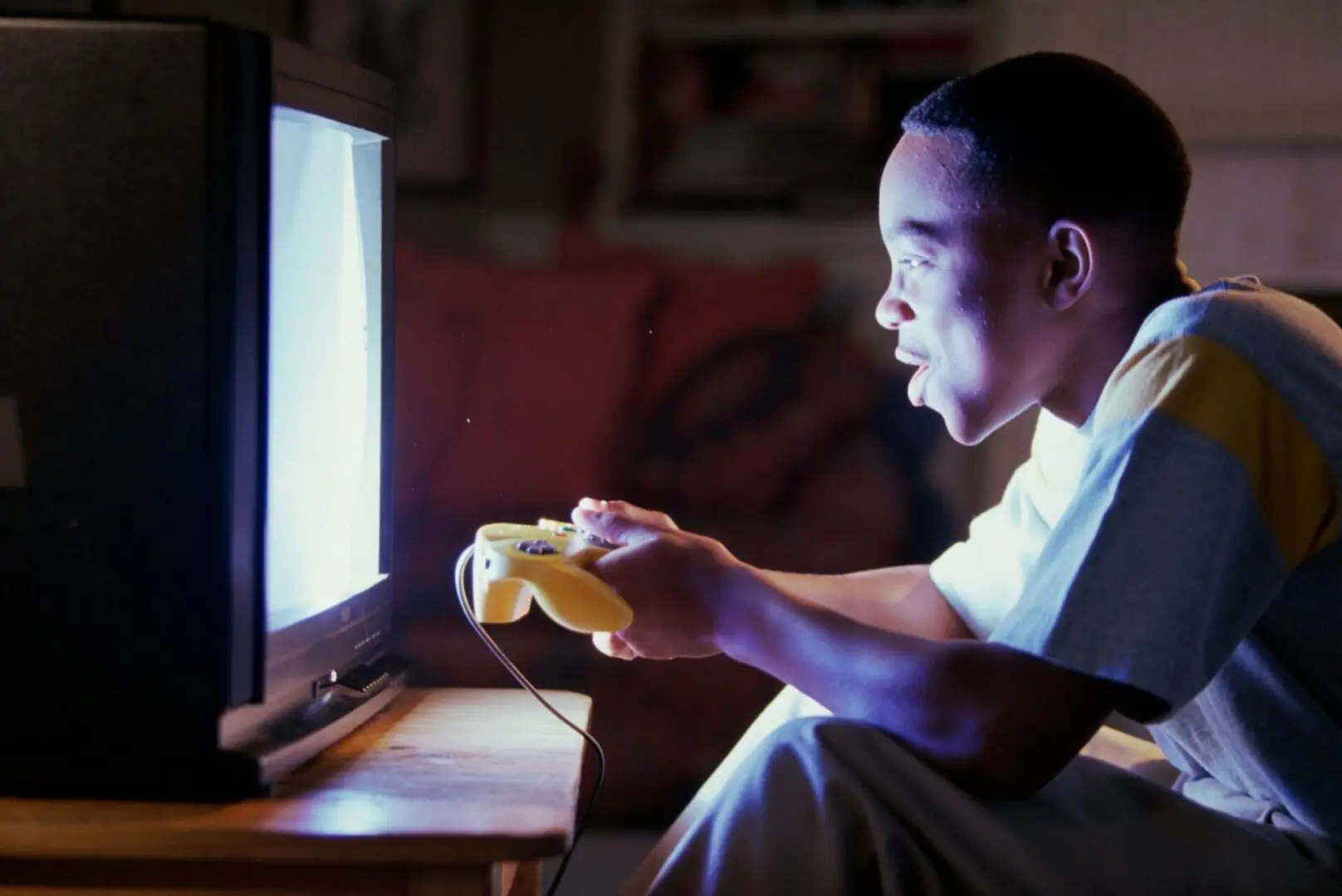 A man intently playing video games while holding a controller.
