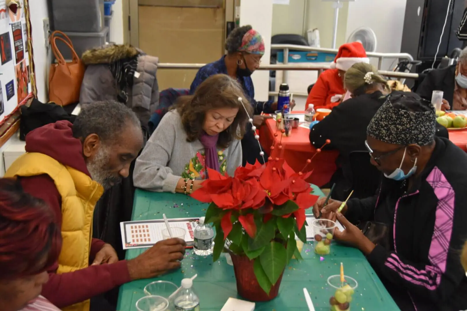 People gathered around a table, focused on an activity during a festive event.