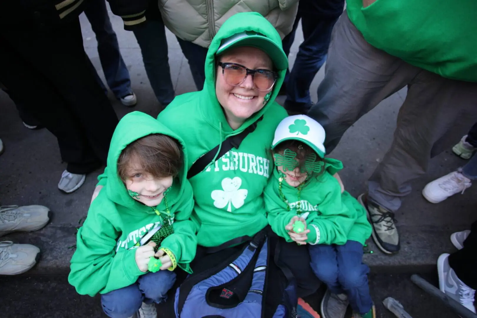 Three people dressed in green for St. Patrick's Day celebration.