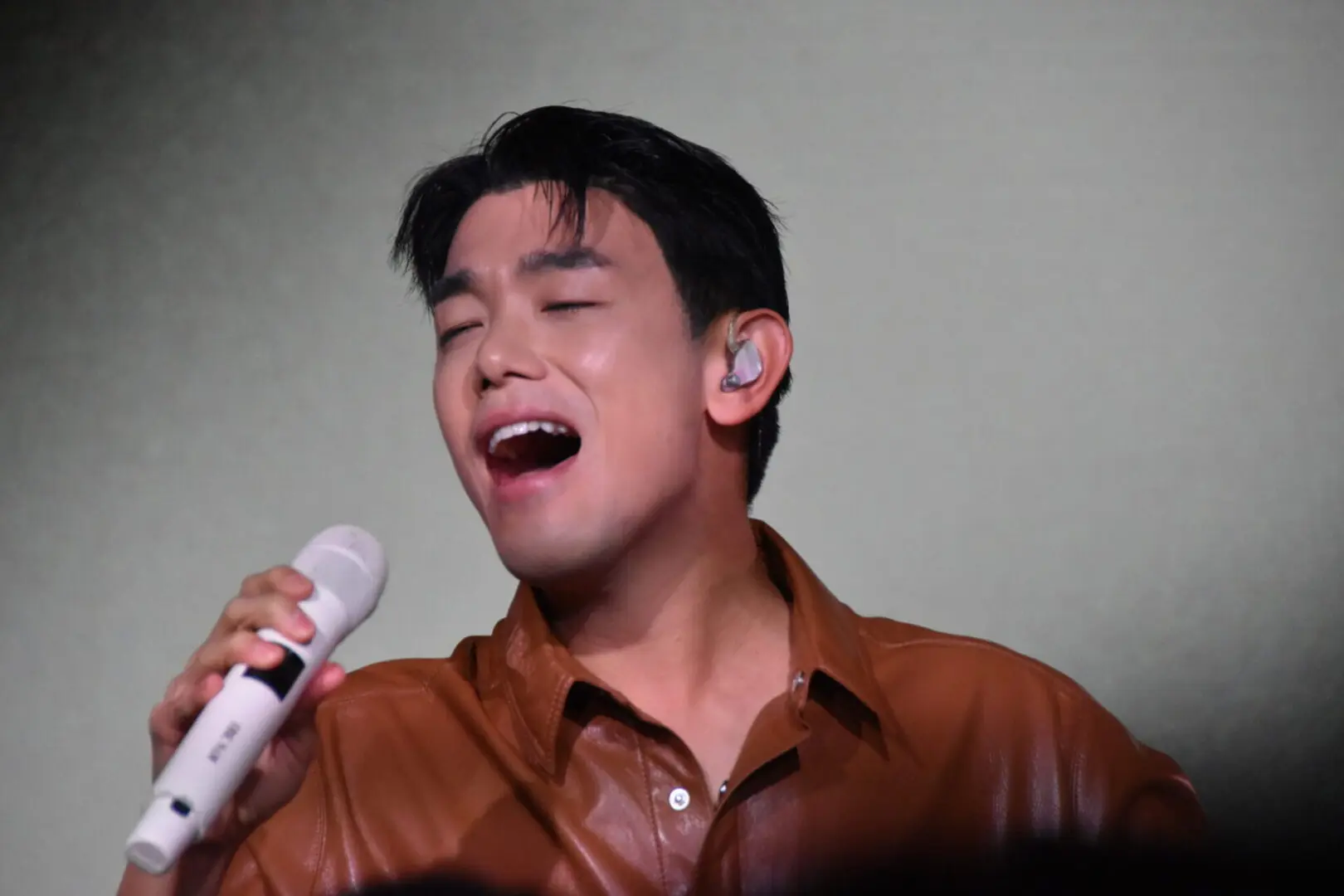 A man passionately singing into a microphone.