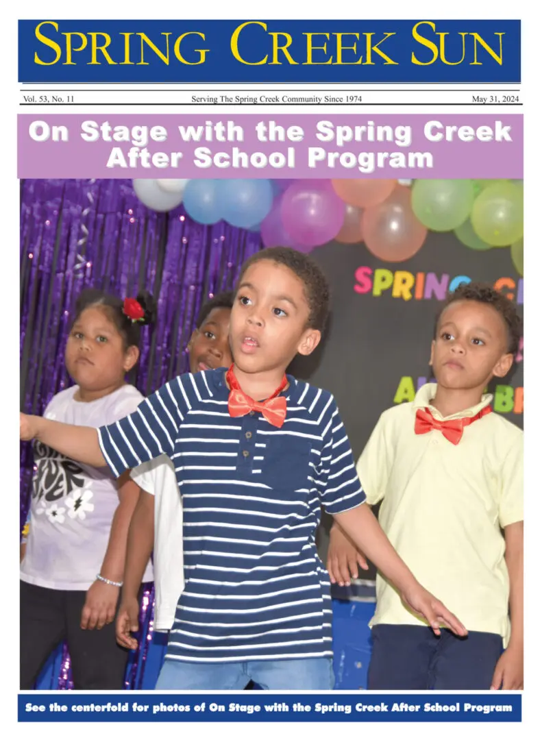 Children performing on stage in a colorful spring-themed event.