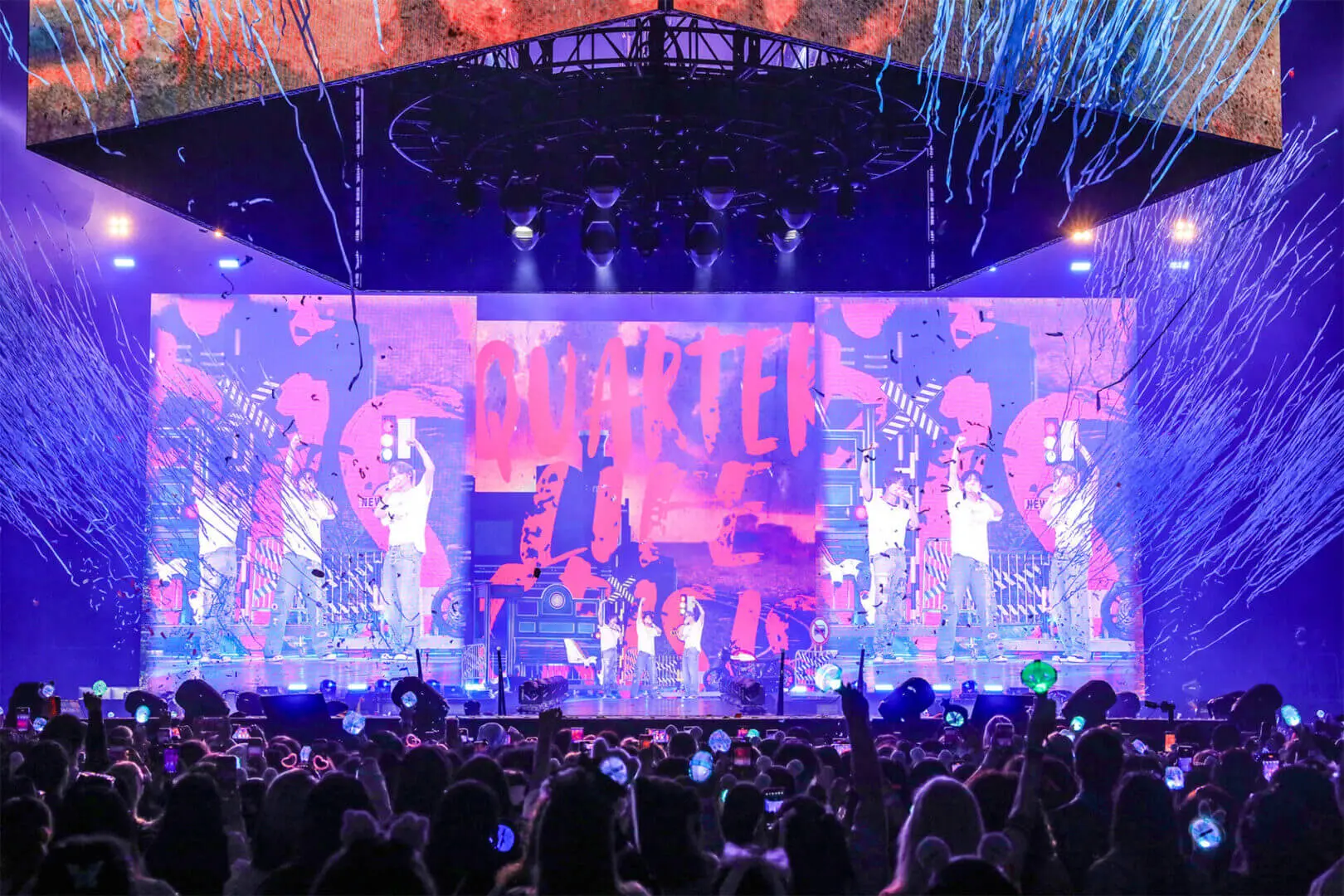 A vibrant concert stage with colorful lights and visuals during a live performance.