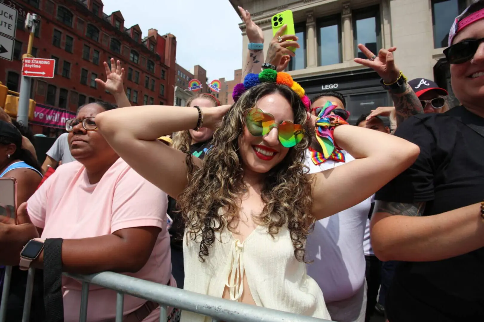 A joyful woman in colorful accessories enjoys a lively outdoor event.