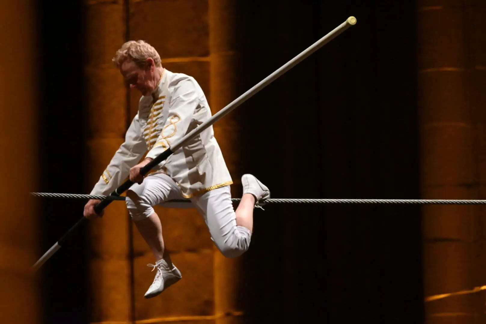 Athlete performing a pole vault jump indoors.