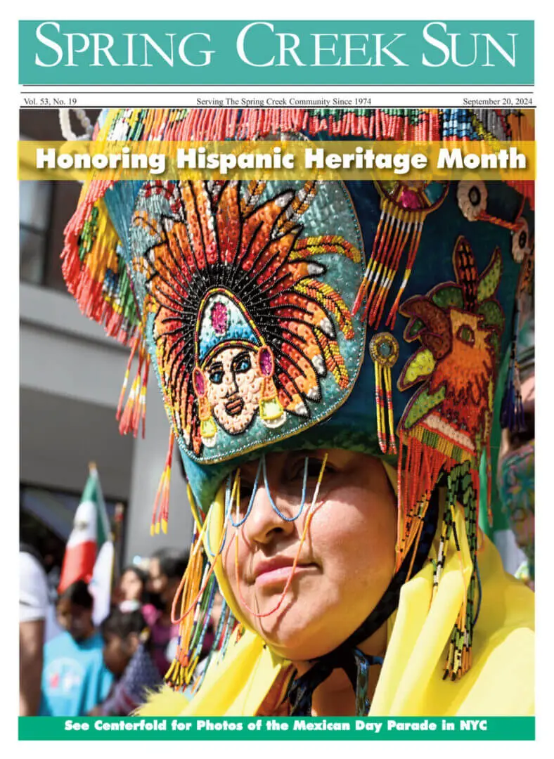 Person wearing traditional colorful Aztec attire celebrating Hispanic Heritage Month.