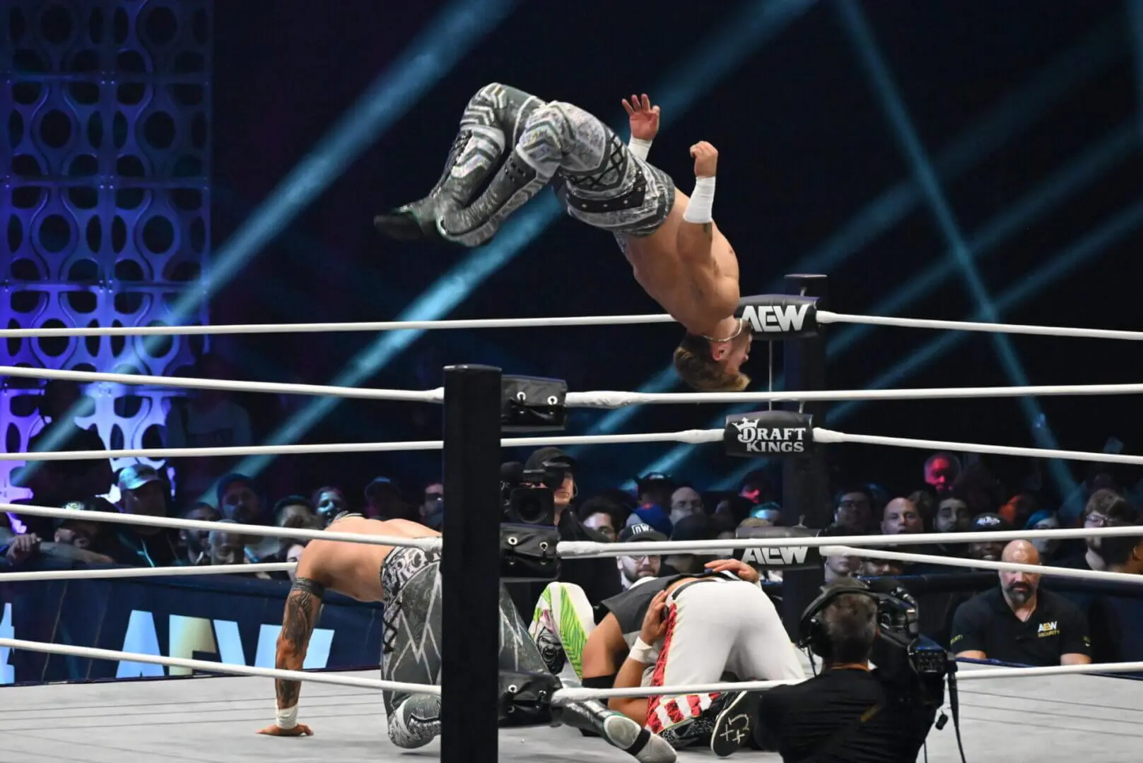 Wrestler performing a high-flying move in a wrestling ring.