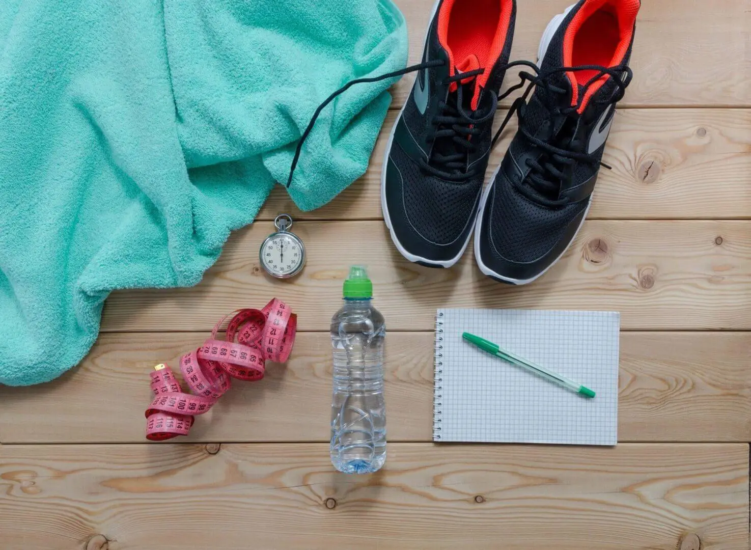 Workout essentials including shoes, towel, water bottle, and stopwatch.