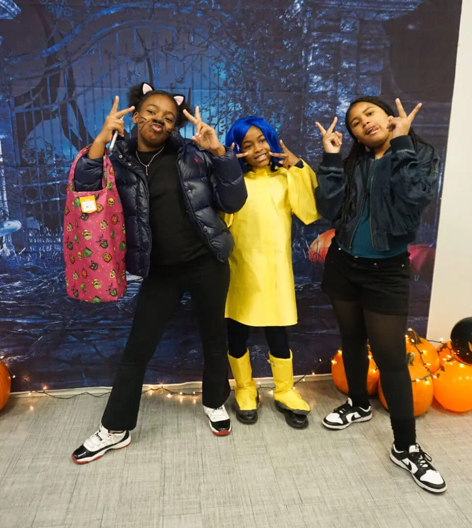 Three people in costumes posing playfully.