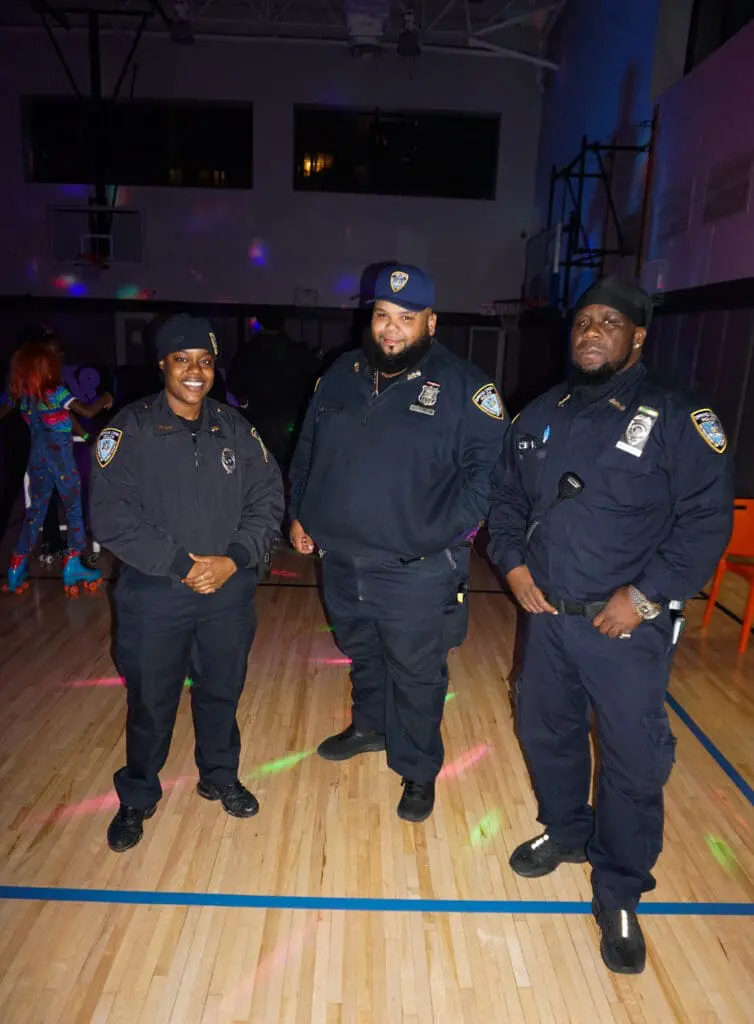 Three officers standing in a gym.