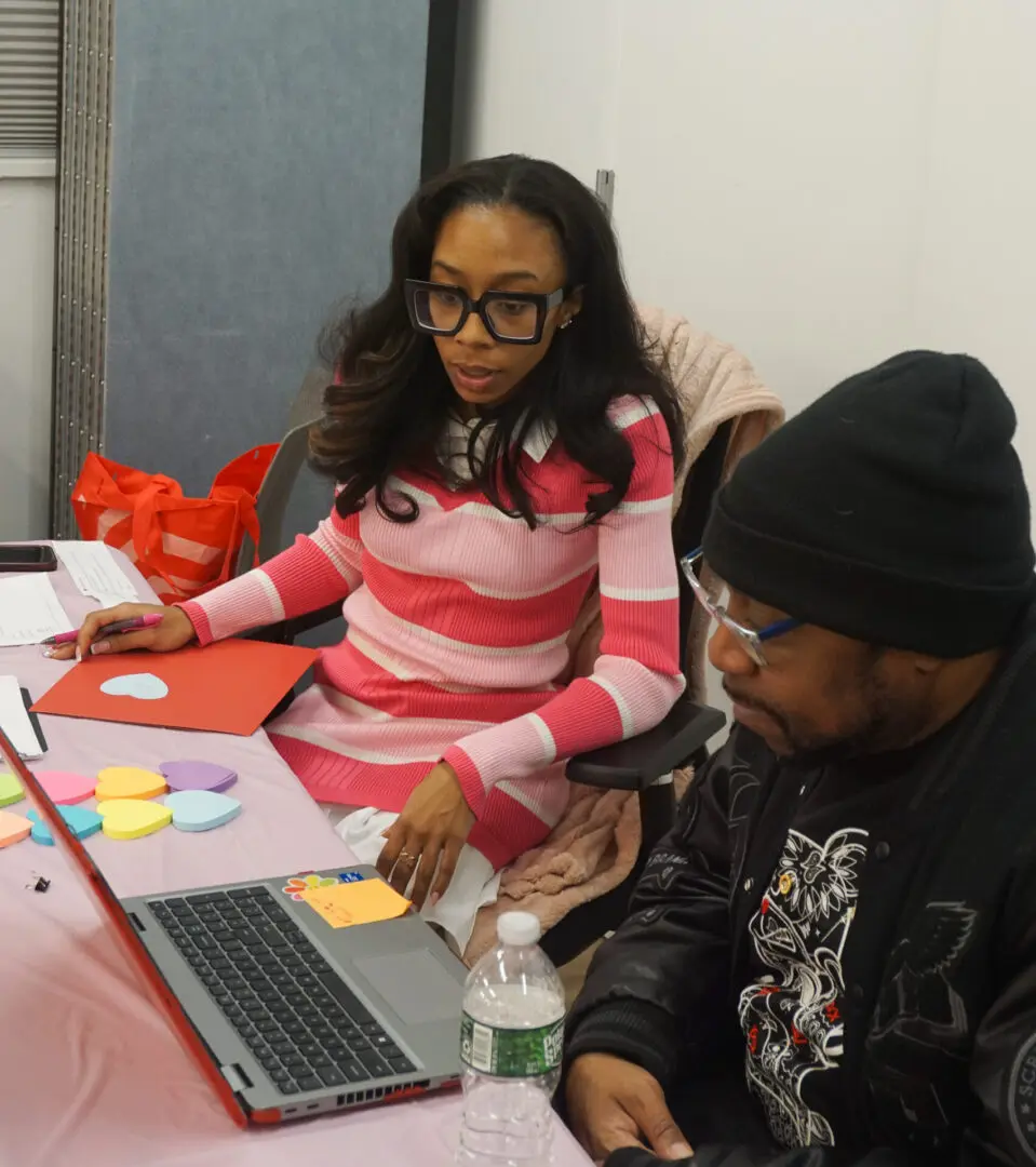 Two people working together on a laptop.